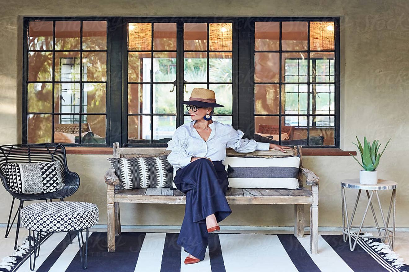 woman sitting on rustic bench in classic attire